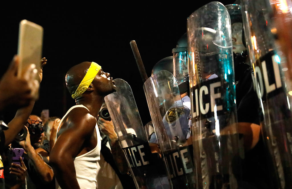 Mell Moffitt shouts at a line of St. Louis riot police